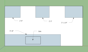 Sketch of kitchen layout with sizes indicating countertop lengths. Walls on all sides except for the right side thus forming a galley kitchen.